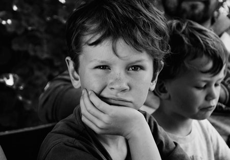 Dos niños mostrando signos de frustración mientras juegan, en un ambiente donde ambos parecen lidiar con dificultades.